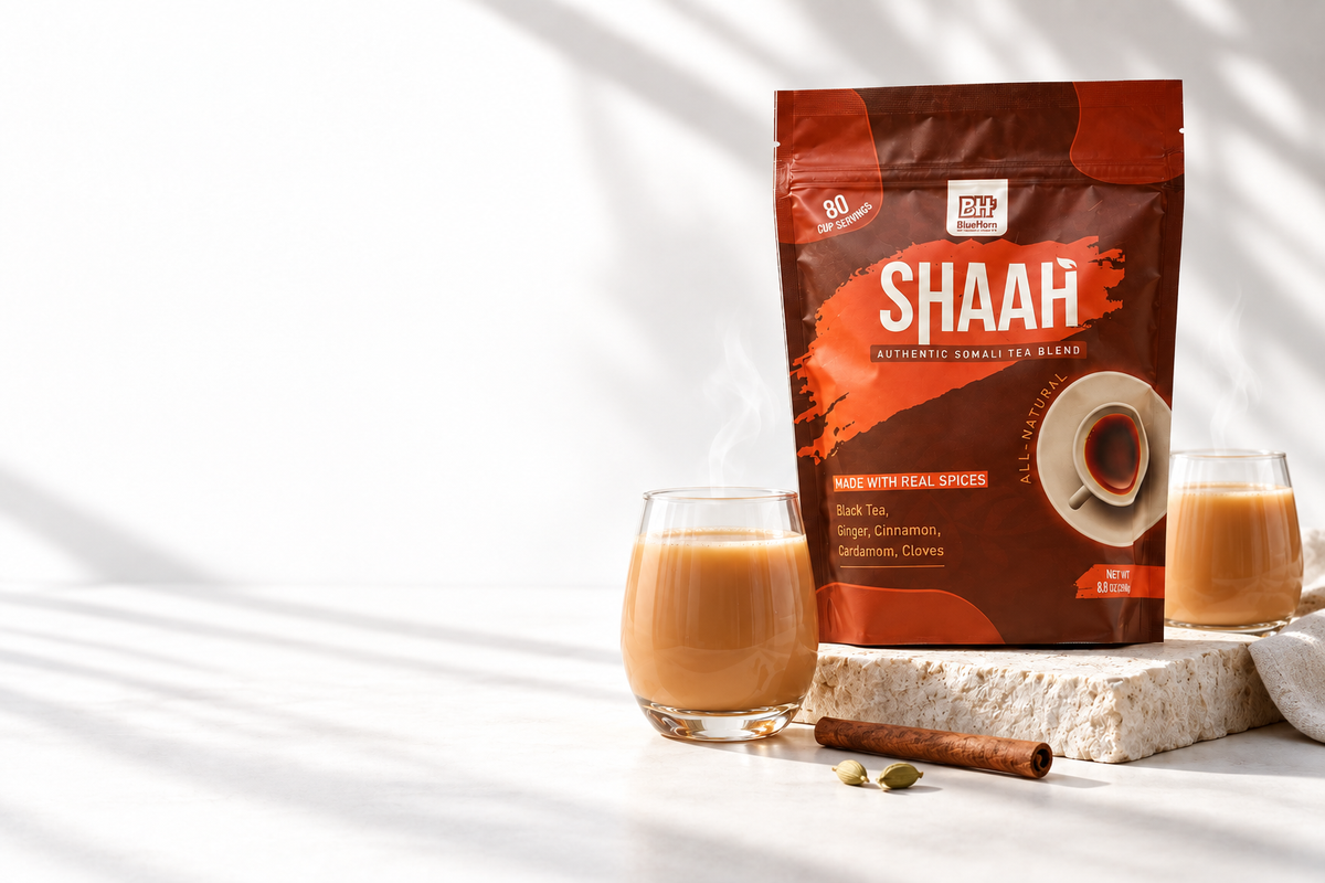 BlueHorn Shaah tea pouch with two glasses of Somali milk tea, cinnamon and cardamom in soft daylight.